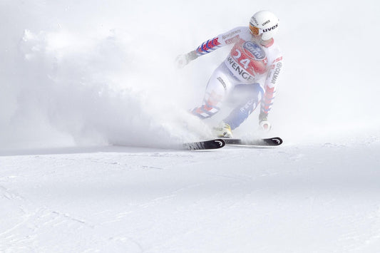 Skier racing through fresh powder snow at the 2026 Winter Olympics trending topics.